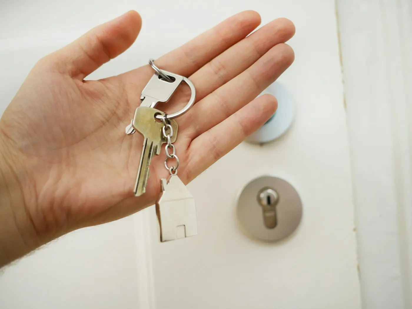 A landlord handing over house keys to a new tenant